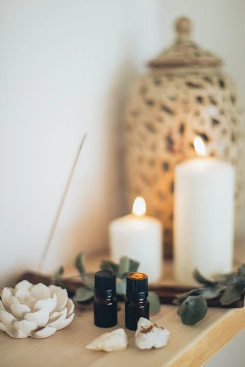 Eucalyptus essential oil set in the bathroom with lighted candles.