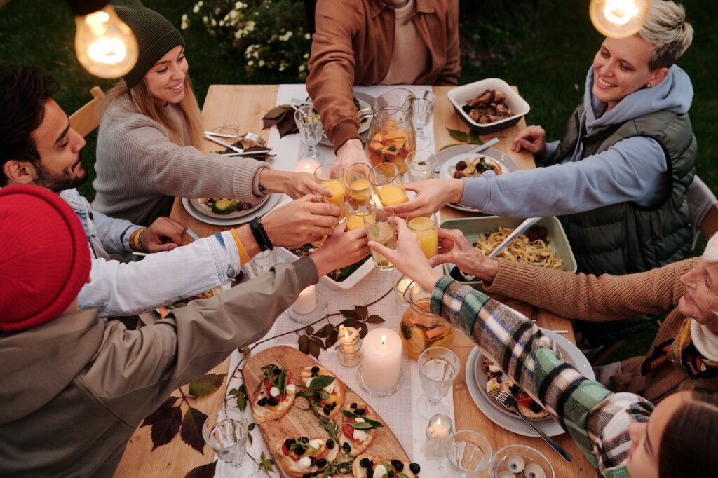 Adults toasting for thanksgiving party. Vibrant decorations in there comfy clothes.