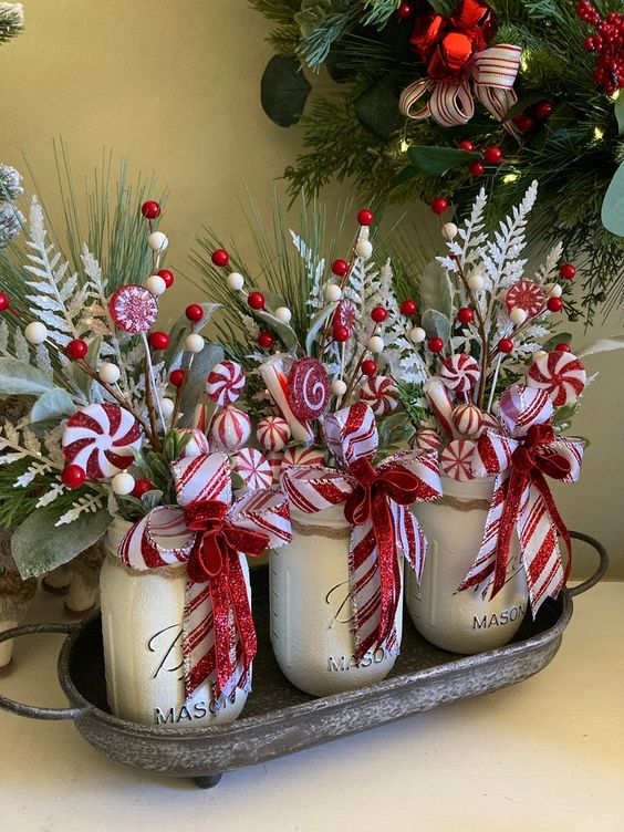 Mason jar centerpiece with Christmas evergreens, holly berry and candy canes.