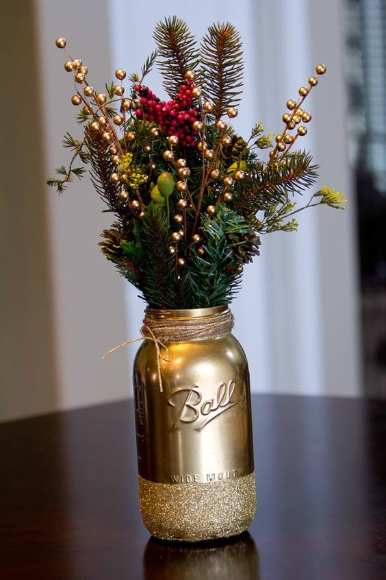 Mason jar painted gold with gold berries as a Christmas centerpiece