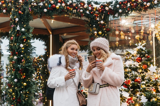 Christmas gift ideas for the boss woman. Two woman using their phones in a winter day.