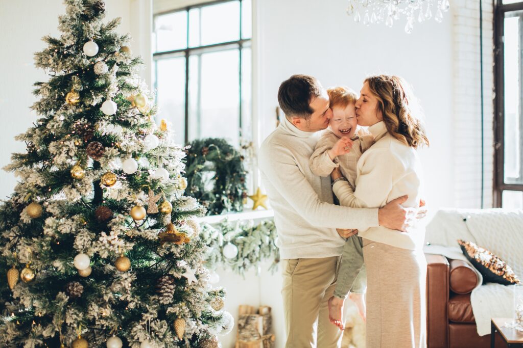 A sweet couple with child beside a Christmas tree, Christmas gift ideas for a couple that has everything.