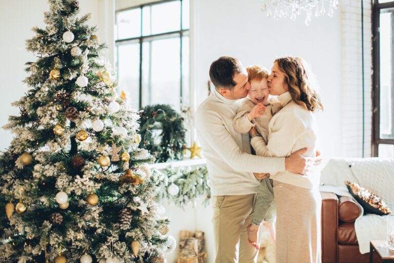 A sweet couple with child beside a Christmas tree, Christmas gift ideas for a couple that has everything.
