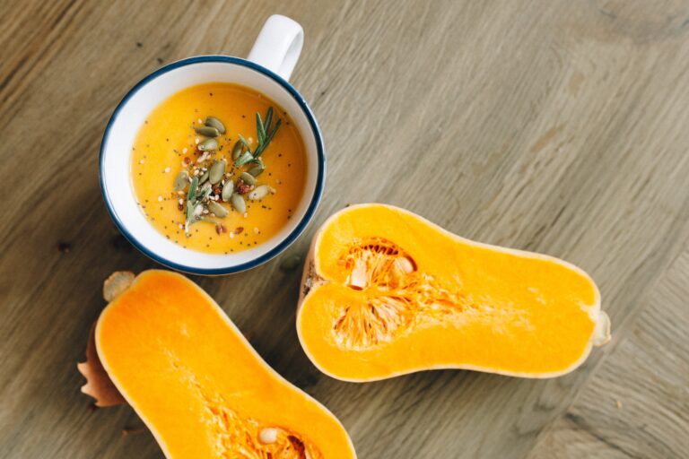 Thanksgiving creamy squash Soup Recipe Ideas in a white with blue rim Thanksgiving soup bowl.