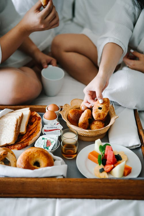 Couple on the bed eating pastries as an indoor winter activities for couples.