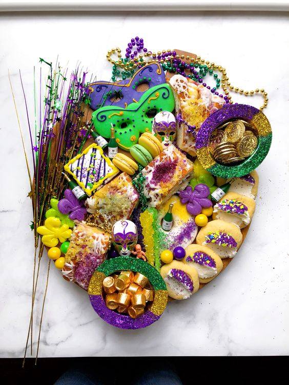 Mardi Gras party ideas for adults desert sttaion of cookies, candies, cakes, macaroons in violet, gold and green colors.