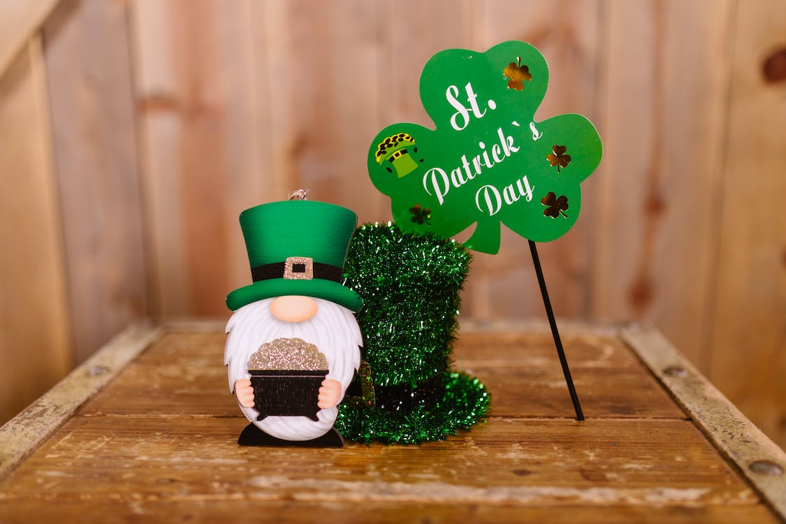 A leprechaun figurine, a green hat and a glover banner as a St Patrick's Day office ideas.