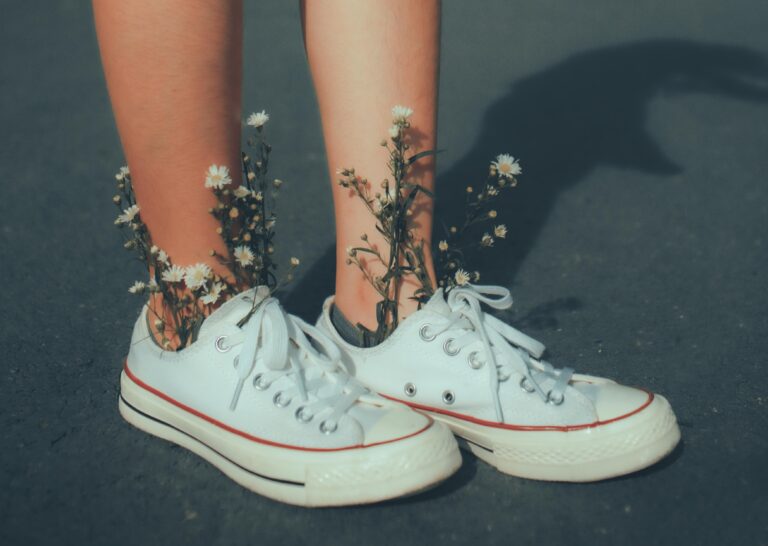 White sneakers with daisies coming out of it, a beautiful centerpiece for a sneaker ball ideas.